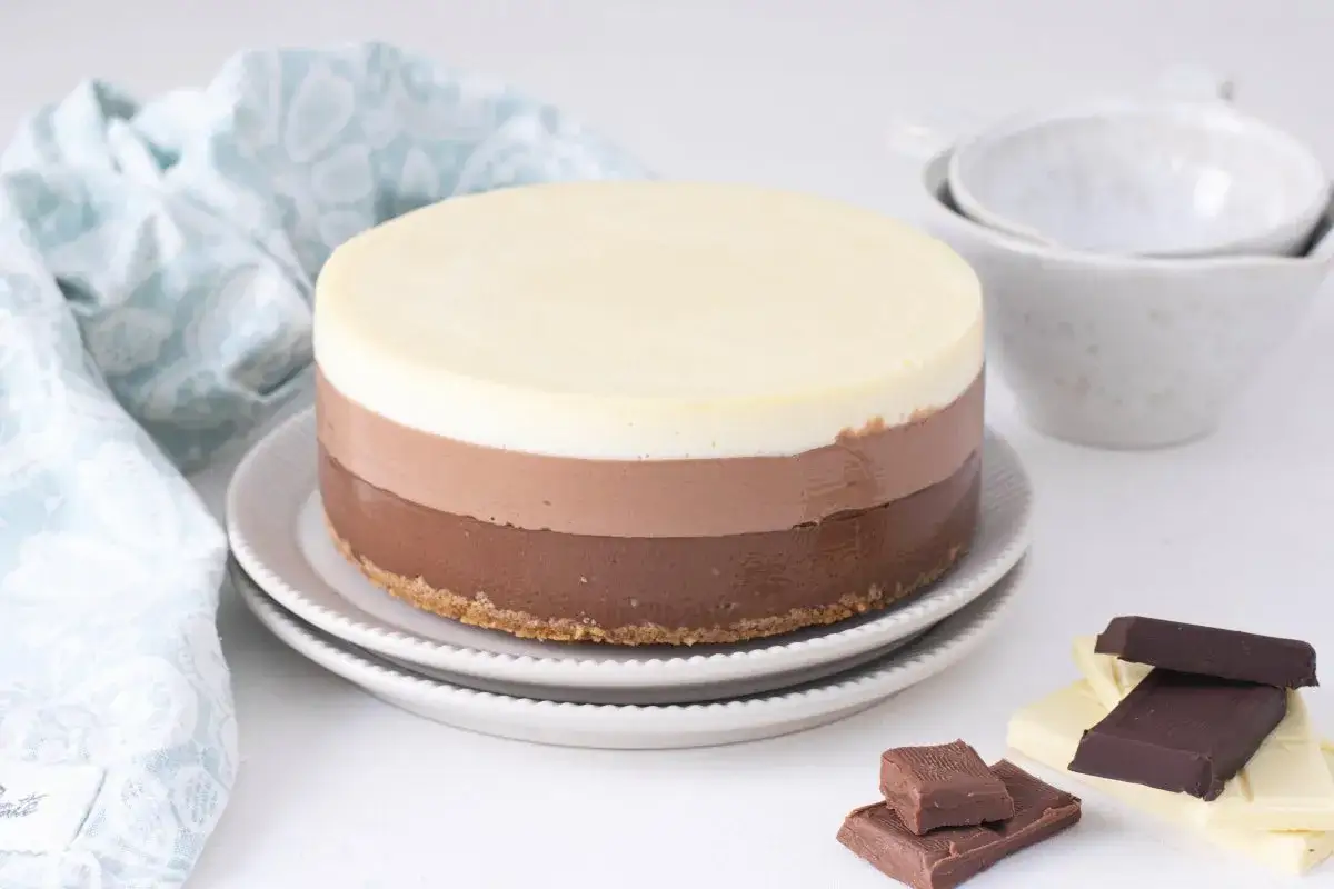 Tarta tres chocolates con capas de chocolate blanco, con leche y negro. Un postre irresistible para los amantes del chocolate.