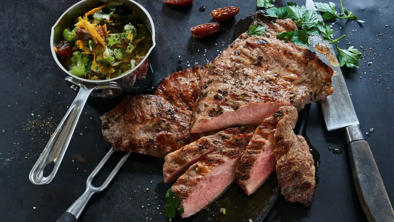 El secreto ibérico, jugoso y a la parrilla, acompañado de una ensalada fresca y dátiles. Un manjar para descubrir.