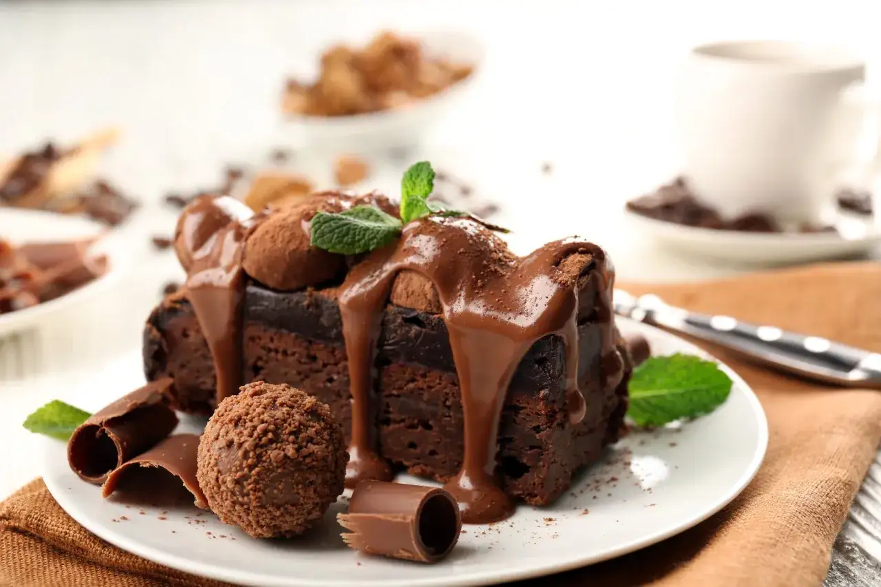 Deliciosa tarta de chocolate, cubierta con glaseado y decorada con menta y trufas. ¡Un placer para la vista y el paladar!