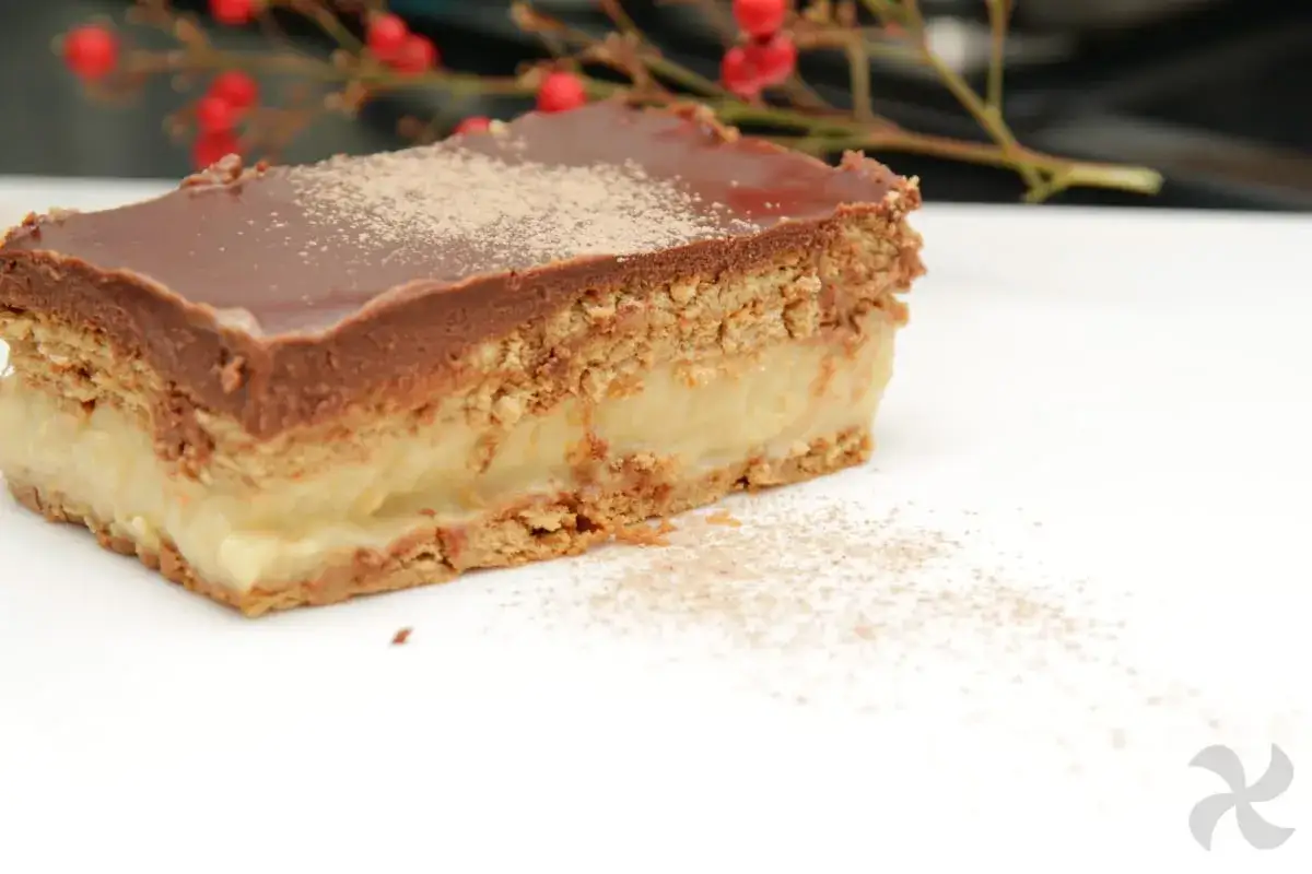 Deliciosa tarta de la abuela Thermomix, con capas de galleta, crema y cobertura de chocolate. Espolvoreada con canela.