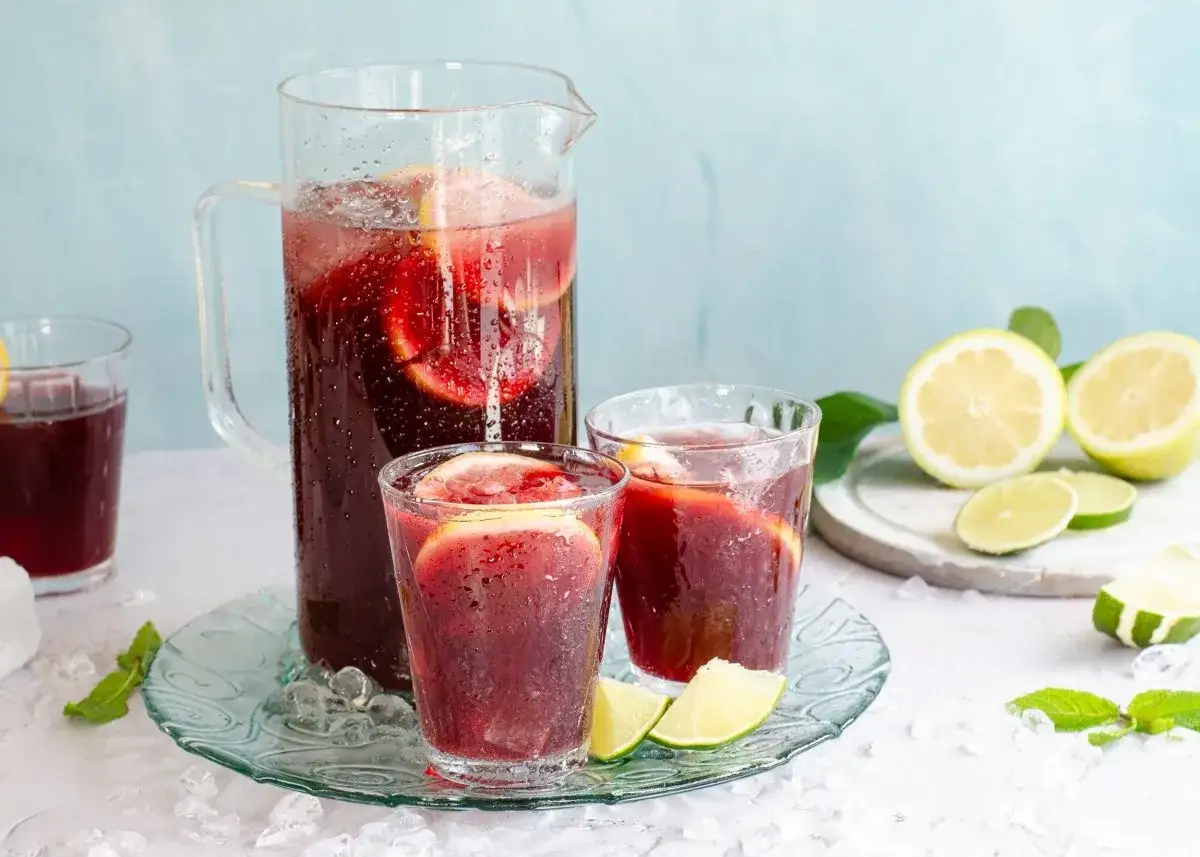 Refrescante tinto de verano en jarra y vasos, con rodajas de lim&oacute;n y lima, hielo y menta. &iexcl;Perfecto para un d&iacute;a caluroso!