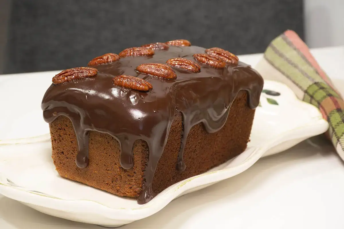Delicioso banana bread cubierto de chocolate y nueces pecanas, listo para disfrutar.