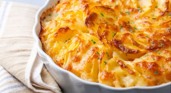 Patatas gratinadas con queso cremoso y trocitos de bacon crujiente, un plato reconfortante y delicioso.
