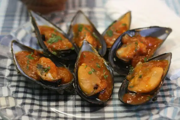 Mejillones en salsa como en los bares, servidos en sus conchas y espolvoreados con perejil fresco.