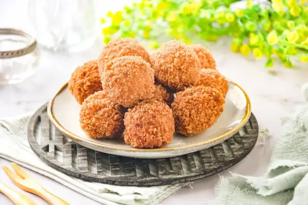 Croquetas de salmón doradas y crujientes, apiladas en un plato, listas para disfrutar.