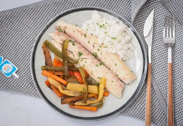 Deliciosa lubina a la sal, servida con arroz blanco y verduras asadas. Un plato saludable y lleno de sabor.