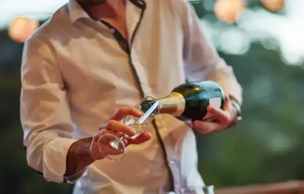 Un hombre sirve cava en una copa. El cava es un vino espumoso español, perfecto para celebraciones.