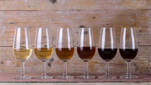 Seis copas de cristal muestran la gama de colores de los tipos de vinos de Jerez, desde el dorado pálido hasta el oscuro.