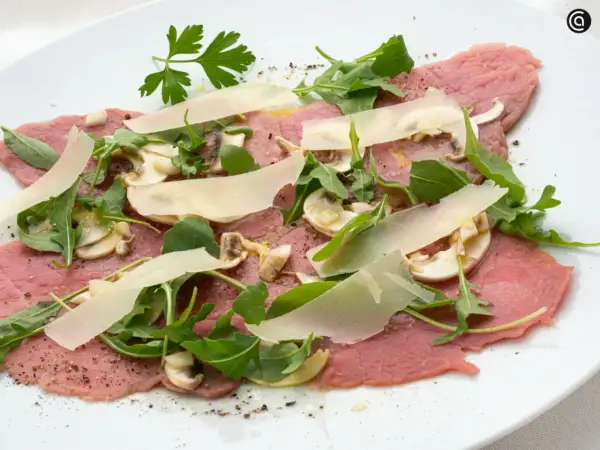 Delicioso carpaccio de ternera con champiñones, rúcula y lascas de parmesano. Un plato fresco y ligero.