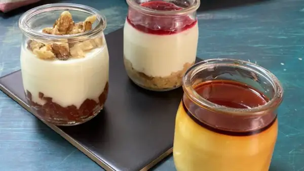 Tres postres en frascos: uno con nueces, otro con mermelada y galleta, y un flan de queso con caramelo.
