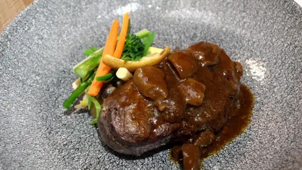 Delicioso solomillo en salsa de la abuela, acompañado de verduras frescas y champiñones. Un plato que evoca recuerdos y sabores caseros.